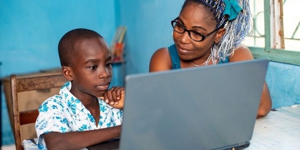Woman with a child in front of a laptop